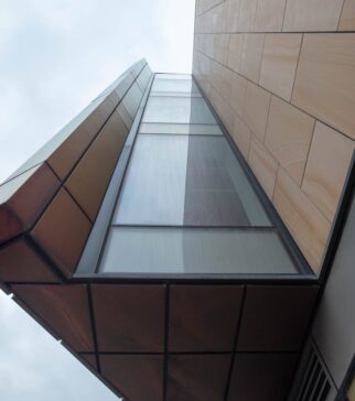 A striking view of contemporary architecture capturing geometric shapes and glass facade from below.